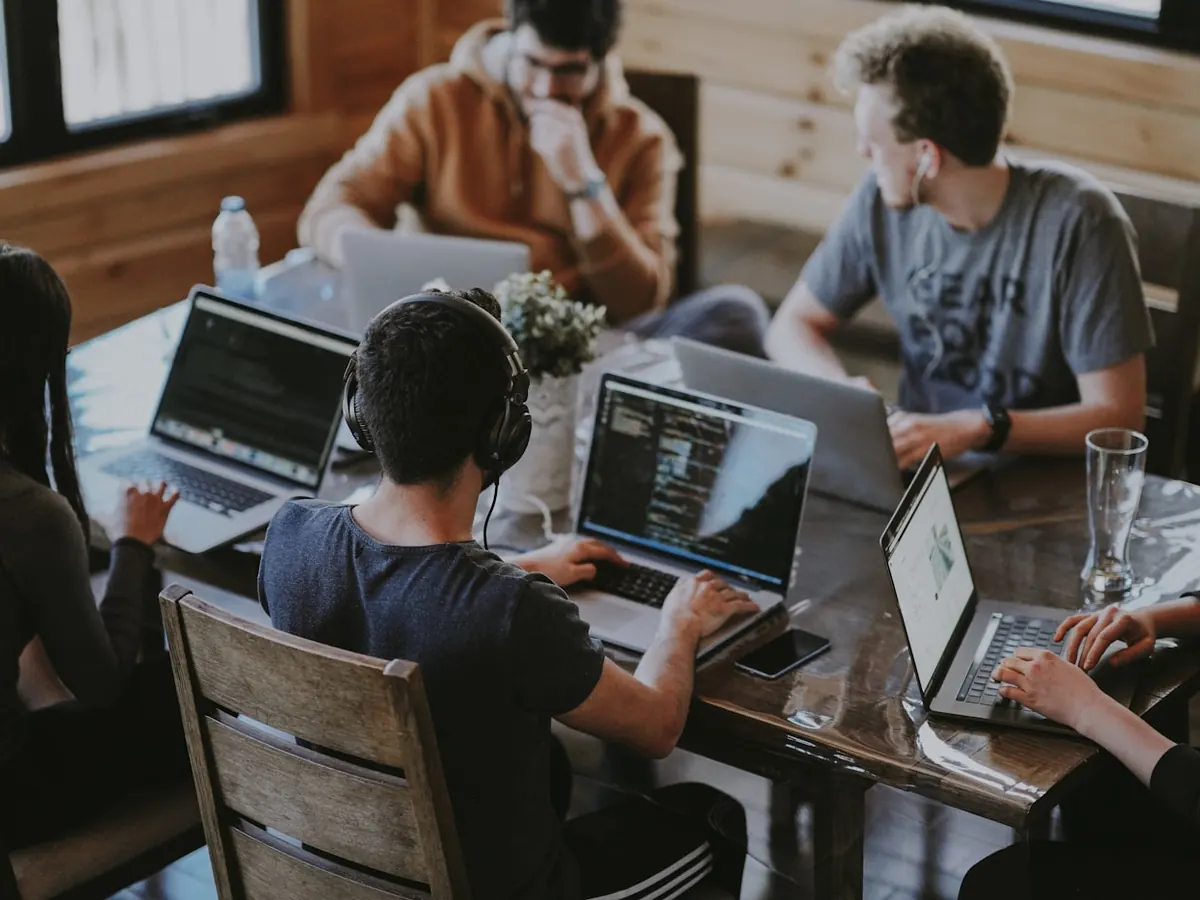 A software team working together on laptops around a table